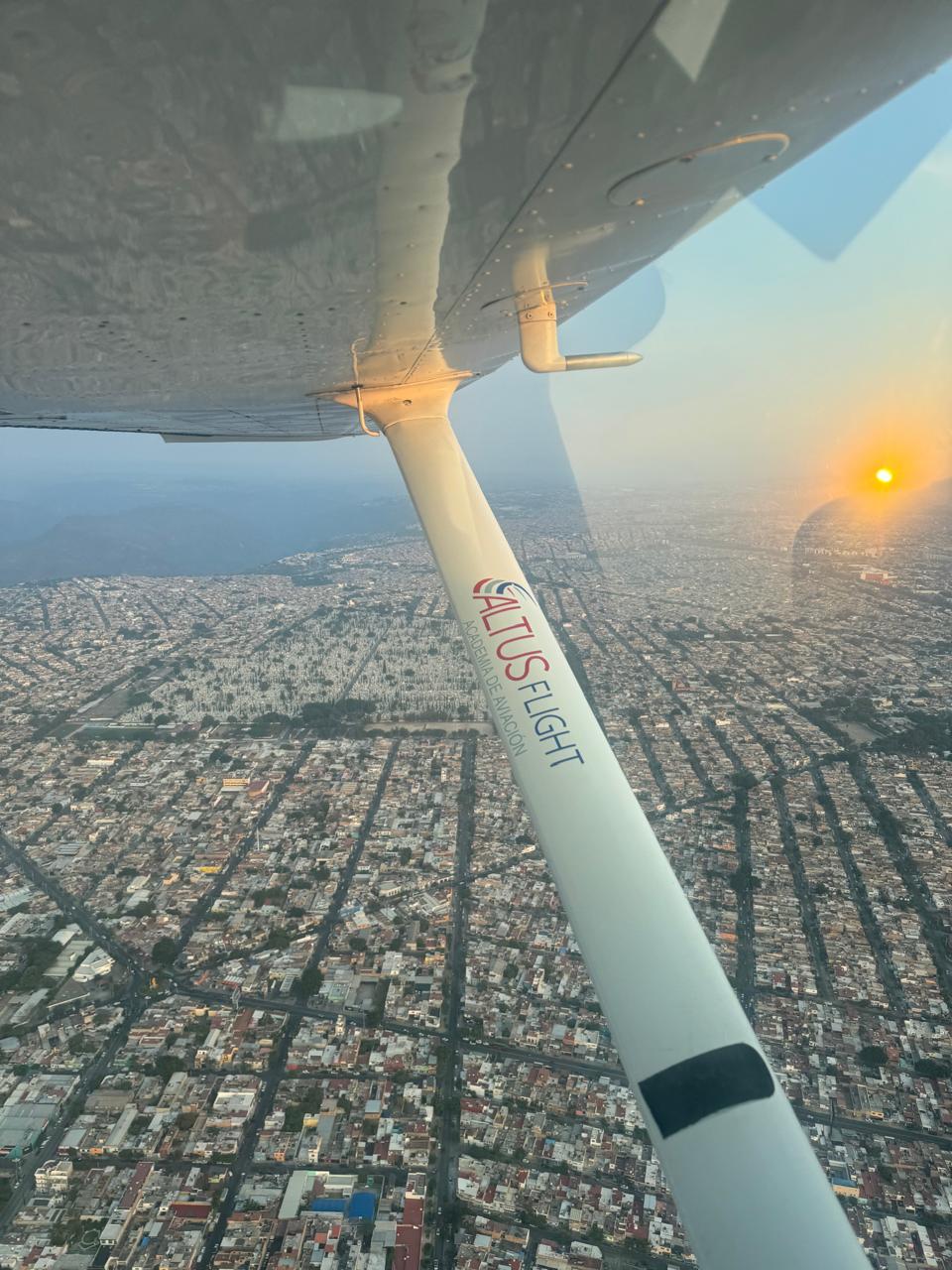 Vista aérea desde Cessna Altus Flight sobre Guadalajara al atardecer